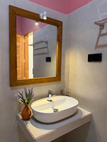 a bathroom with a white sink and a mirror at Piña Boutique Hotel - Beachfront in Habaraduwa Central