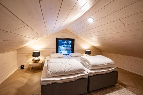 a bedroom with two beds in a room with a ceiling at Vuokatti Weekend Platinum in Vuokatti