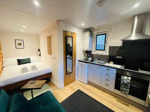 a small room with a bed and a kitchen at The Canal Cabin in Banavie
