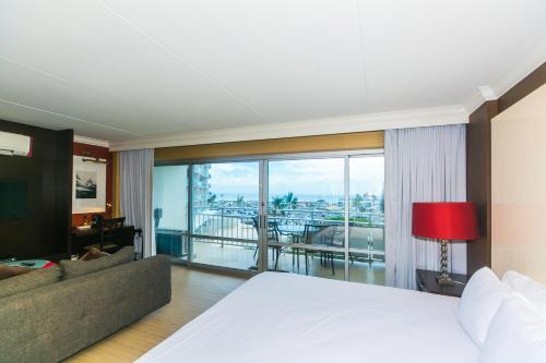 a bedroom with a bed and a living room at Ilikai Tower 404 in Honolulu