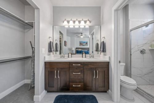 a bathroom with a sink and a toilet and a mirror at Adventures Base! Family Friendly w heated community pool in Washington