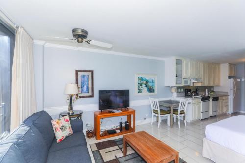a living room with a blue couch and a kitchen at Ilikai Marina 987 in Honolulu