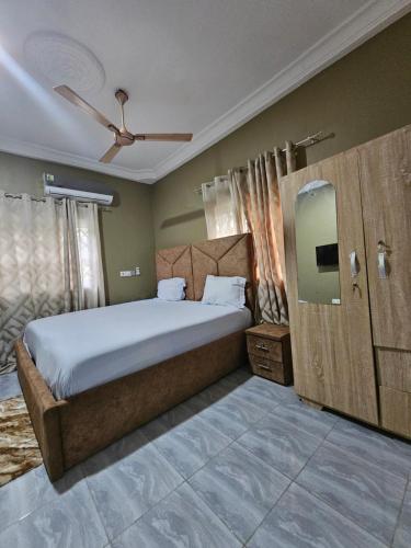 a bedroom with a large bed and a ceiling fan at Gifted Estates in Accra