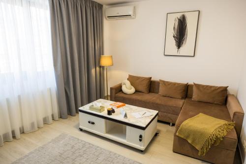 a living room with a couch and a coffee table at Le Blanc ApartHotel in Bucharest