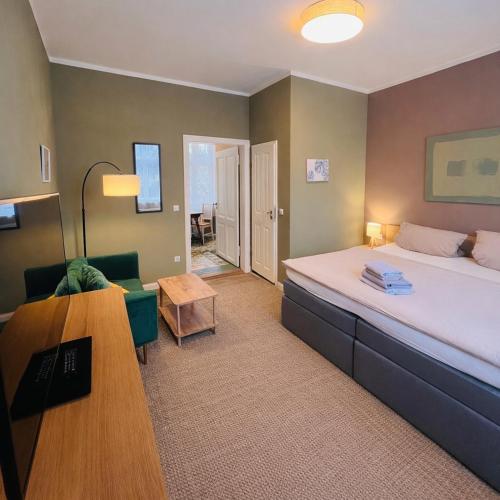 a bedroom with a bed and a couch and a table at Pension im historischem Bahnhof in Fehrbellin kein Frühstück in Fehrbellin