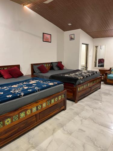 a bedroom with two beds and a couch at Amor Villa Abu in Mount Ābu