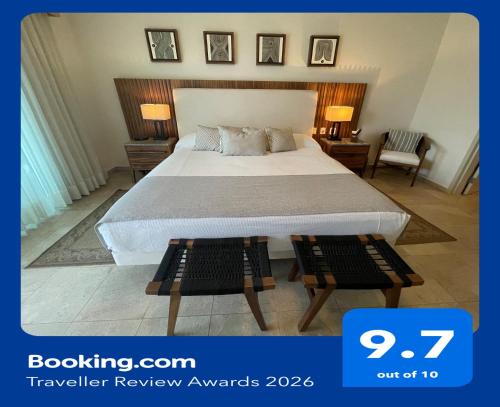a hotel room with a bed and two tables at Beachfront 2 bedroom Condo in Playa Royale Resort, Nuevo Vallarta in Nuevo Vallarta