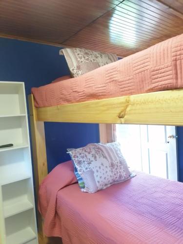 a bedroom with two bunk beds with pink sheets at Apartamento Cuadruple in Isla de Maipo