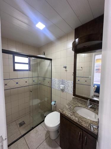 a bathroom with a toilet and a sink and a mirror at Vista Beach Ingleses in Florianópolis