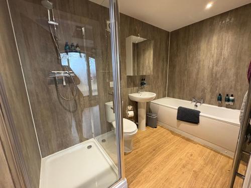 a bathroom with a shower and a toilet and a sink at The Granary, Wolds Way Holiday Cottages, spacious 3 bed cottage in Cottingham