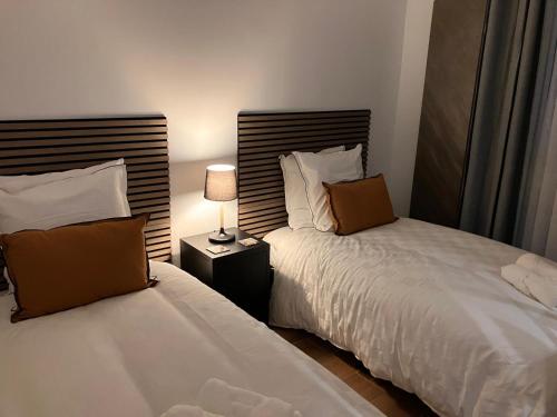 a bedroom with two beds and a lamp on a night stand at Calm & Cozy Apartment with Parking in Sallanches in Sallanches