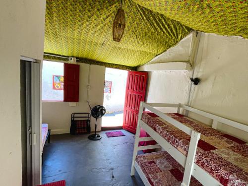 a room with two bunk beds and a red door at Colombia Hostel in Porto Seguro