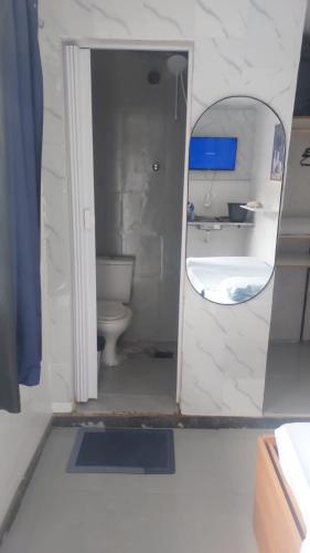 a bathroom with a toilet and a sink and a mirror at Alure 1 in Belo Horizonte