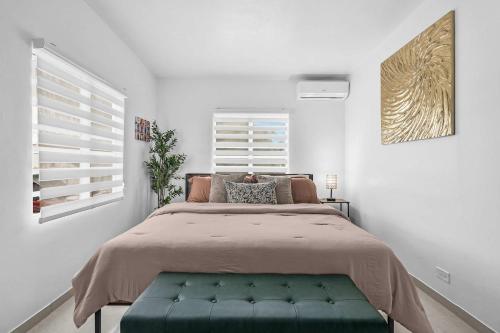 a bedroom with a large bed with a green bench at Bay View by Otium in Catano