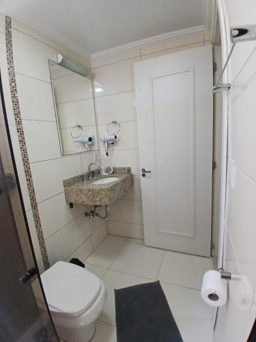 a bathroom with a toilet and a sink and a mirror at HOTEL MARIANI in Lajeado
