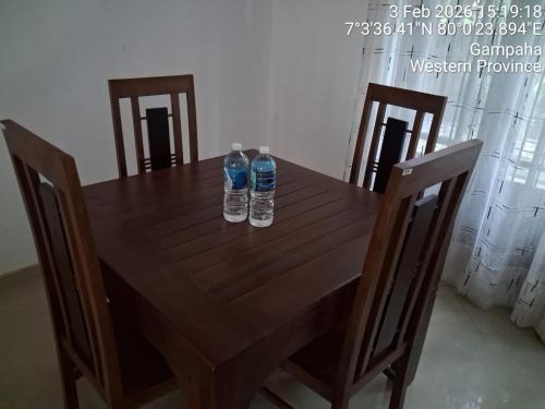 two bottles of water sitting on top of a wooden table at Slayan-1 properties in Mudungoda