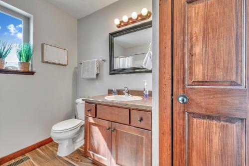 a bathroom with a toilet and a sink and a mirror at Bridges Bay Vacation Cabin 33 in Arnolds Park