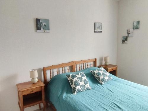 a bedroom with a blue bed with two night stands at Logis de LANGE apt les Ecureuils in Saint-Hilaire-la-Palud