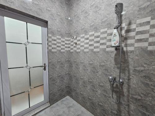 a shower with a glass door in a bathroom at Gifted Estates in Accra