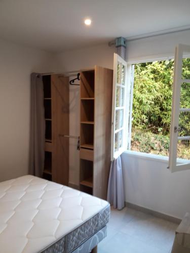 a bedroom with a bed and a window at Le repos des crêtes in Cavalaire-sur-Mer