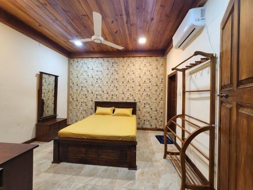 a bedroom with a bed and a ceiling fan at Mahizh Manai in Jaffna