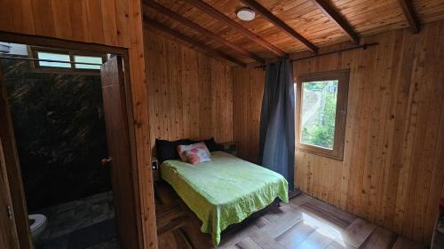 a small bedroom with a bed in a wooden cabin at Aitana Mágica in Copacabana