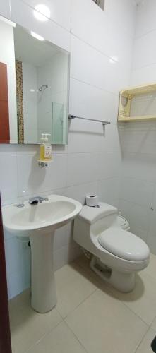 a white bathroom with a toilet and a sink at Costa Azul Suites 802 in Santa Marta