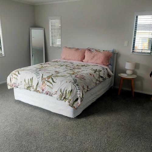 a bedroom with a large bed with a mirror at One8Endeavour in Tauranga