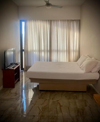 a bedroom with a large bed and a window at Flat Próximo Shopping Santa Úrsula in Ribeirão Preto