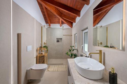 a bathroom with a white sink and a toilet at Villa Christalia in Kolymbia