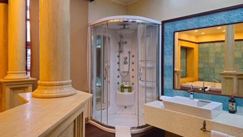 a bathroom with a shower and a sink and a mirror at Eski Masal Hotel - Special Class in Antalya