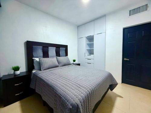 a bedroom with a large bed and a black door at Casa Marsella Privada y Moderna 1 in Zaragoza