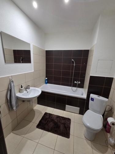 a bathroom with a toilet and a sink and a tub at Apartmán KN in Liptovský Mikuláš