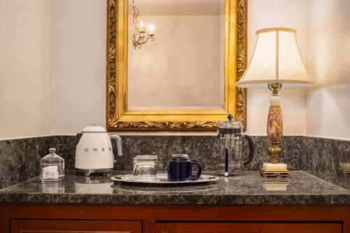 a table with a lamp and a coffee maker on it at Arizona Inn in Tucson