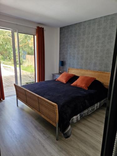 a bedroom with a large bed and a large window at Villa Nelson Classée 3 étoiles in Moliets-et-Maa