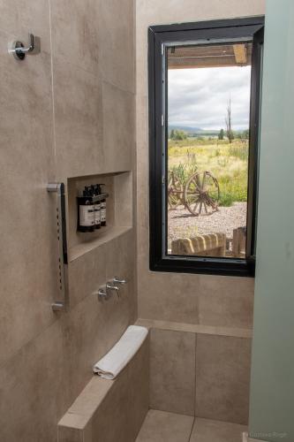 a bathroom with a shower with a window at Rancho Adobe Eco Hotel in Tupungato