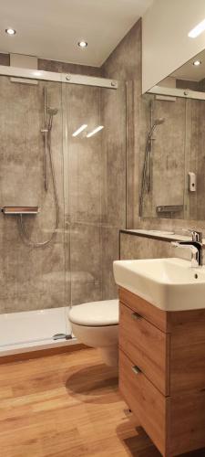 a bathroom with a shower and a toilet and a sink at Hotel Restaurant Verst in Gronau