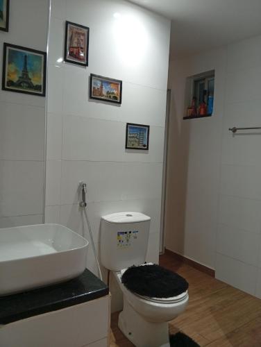 a bathroom with a white toilet and a sink at T&S Guest House in Praia