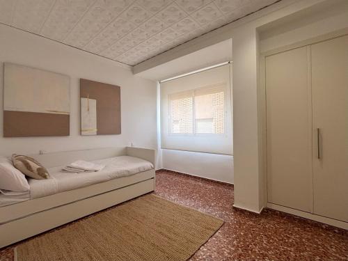 a white room with a bed and a window at Cosy Flat Catarroja in Catarroja