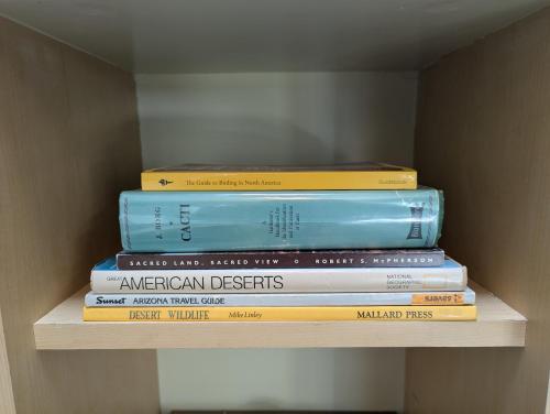 a stack of books sitting on top of a shelf at Early Birds in Tucson