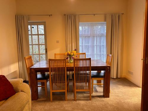 a dining room with a wooden table and chairs at Deandale Stays in Handforth