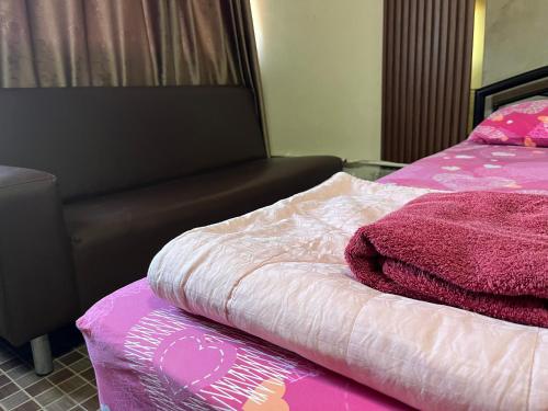 a bedroom with a bed with pink and white sheets at Impact Arena C4 by Jintana in Ban Bang Phang