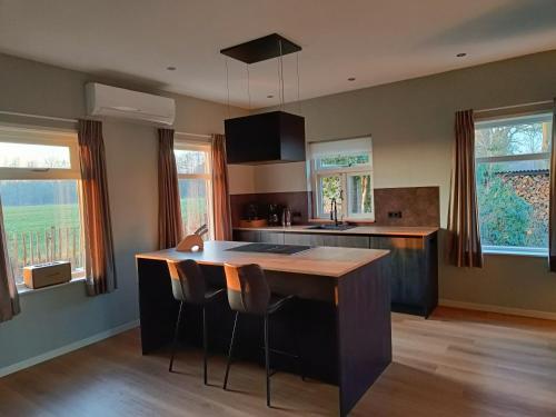 a kitchen with a island with a wooden counter top at Vakantiewoning met hottub en bedstede - De Kruidenhoeve in het Reestdal in Balkbrug