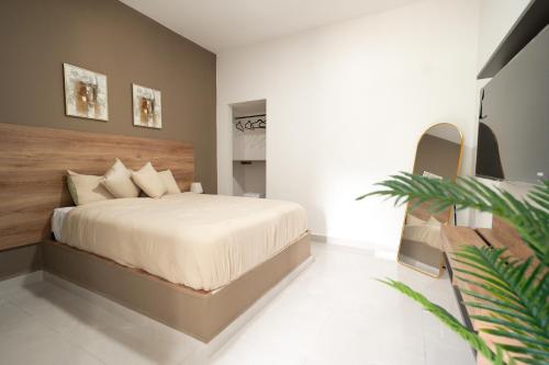a bedroom with a large bed with a wooden headboard at La Palma Experience in Panama City