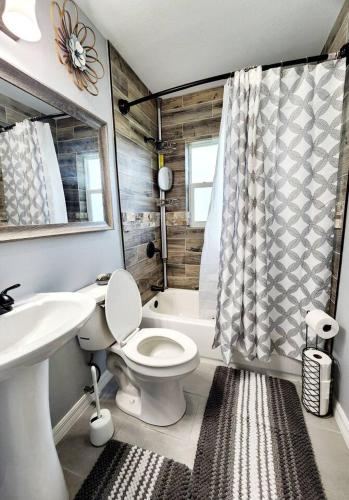a bathroom with a toilet and a sink and a tub at Blue Door House in Lakeland