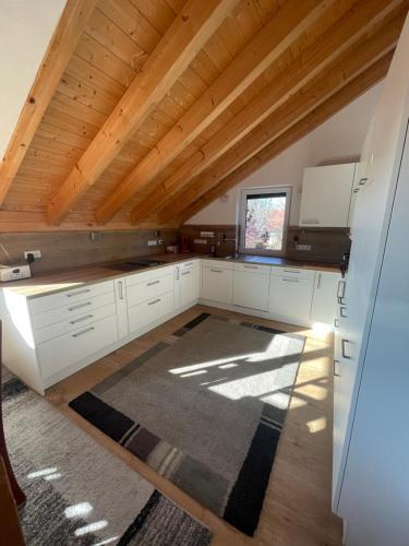 a kitchen with white cabinets and a wooden ceiling at Bordinghouse Arndt in Memmingen