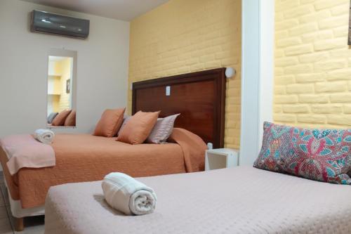 a hotel room with two beds and a mirror at Hosteria Amparo in Neuquén