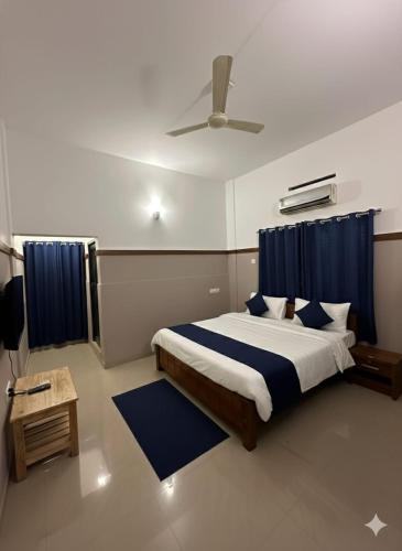 a bedroom with a bed and a ceiling fan at The Rosetta Inn, Wayanad in Wayanad