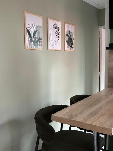 a dining room with a table and four pictures on the wall at La Petite Maison in Brest