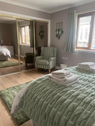 a bedroom with a large bed and a mirror at Fraoch, Pets welcome in Port Bannatyne